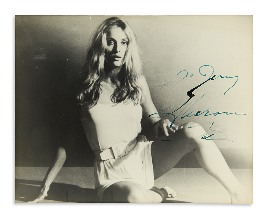 TATE, SHARON. Photograph Signed and Inscribed, To Jerry, full-length portrait, showing her barefooted wearing a short white dress and